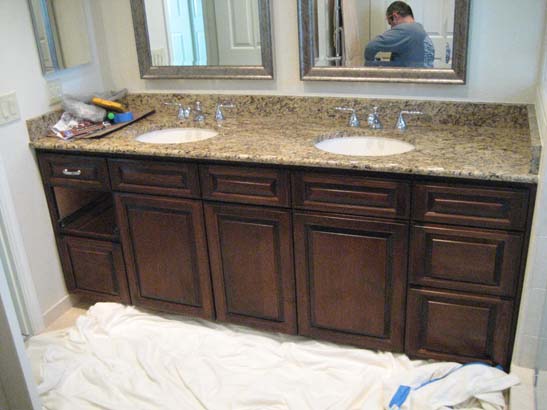 Granite topped cherry-wood counter with rags beneath it to catch work debris