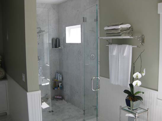 Glass shower door with white granite tile for flooring and walling