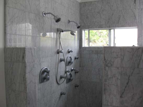 White granite shower with stainless steel fixtures