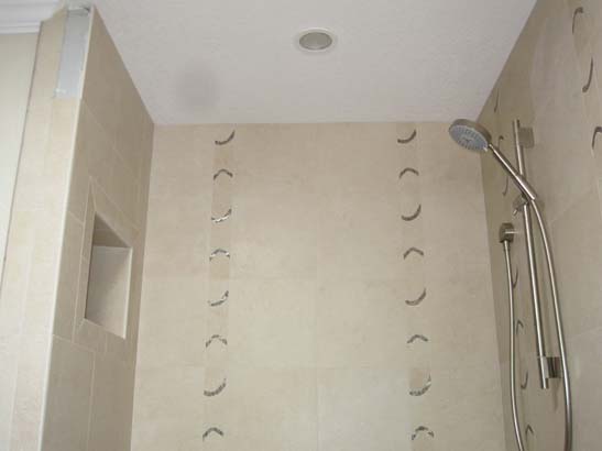 White mosaic tile shower with tan borders