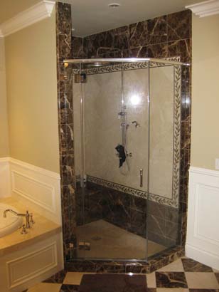 Angled glass shower in a brown and tan tiled bathroom